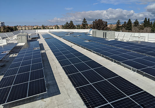 Bifacial solar panels collect the sun’s rays on both sides of the panels, which are installed on “tables” above the roof’s surface to make use of both sides.